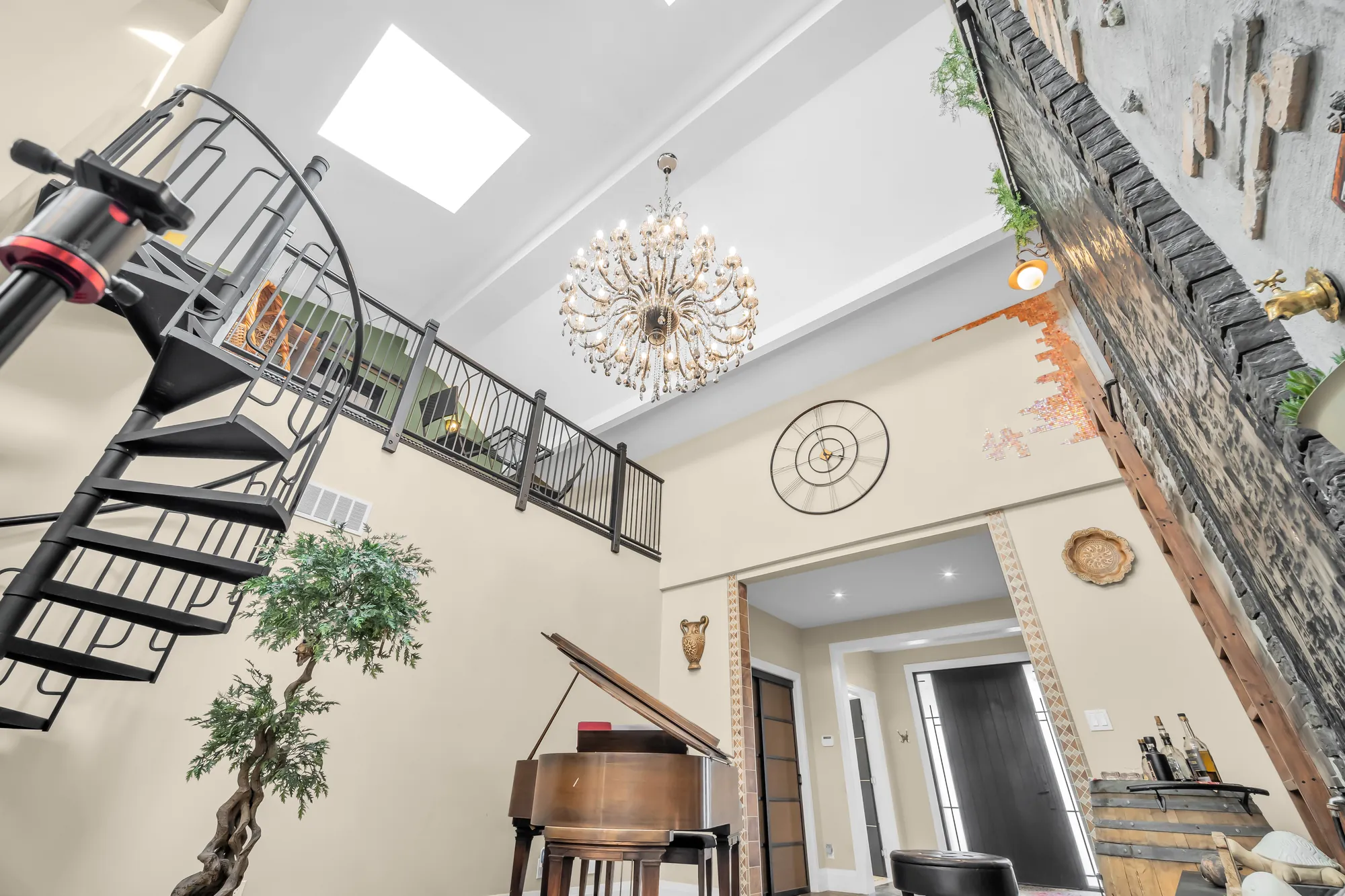 Looking up in the flex area: the black spiral stair, the loft railing, skylights and a chandelier