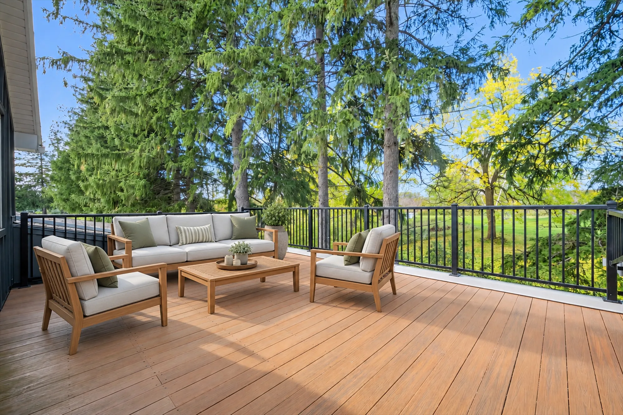 The same balcony, virtually staged with an outdoor sofa, two armchairs, a coffee table and a potted plant