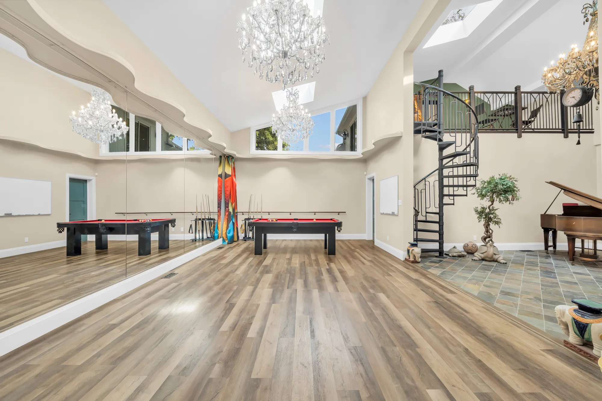 The length of the recreation room: two pool tables, a wall of mirrors, the spiral stair and the flex area at the end