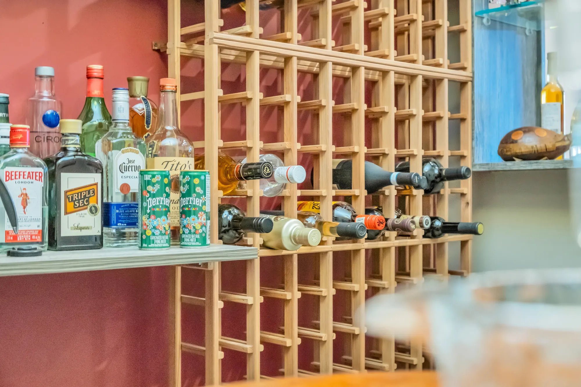 Bottles in the wooden wine racks and spirits on a shelf